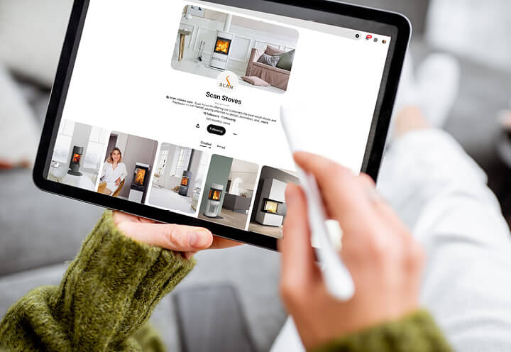 Nærbillede af hænder, der holder en tablet og scroller på pinterest