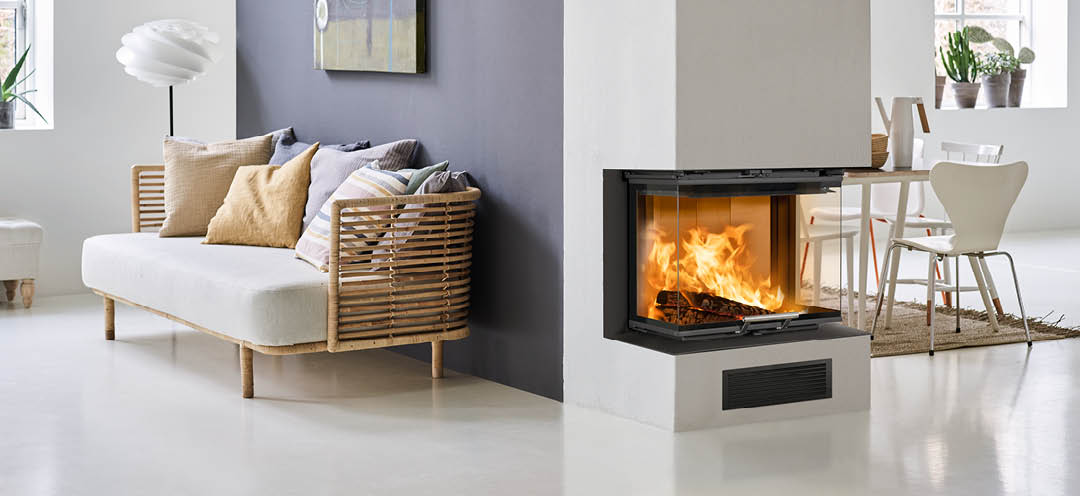 Hvid stue med bambus sofa og en lilla væg med pejs på endevæg og pejseindsats Scan 5004 FRL med glas på tre sider